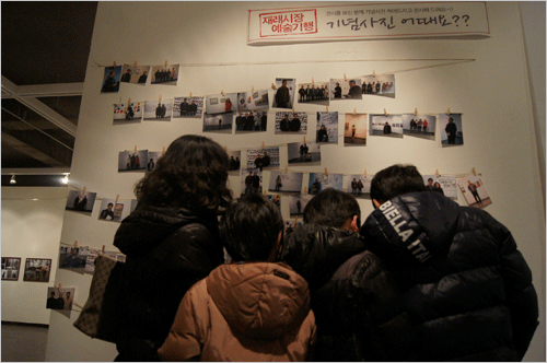 현장에서 찍어준 사진을 기념으로 미술관 시민참여 공간에 자신의 사진을 붙이고 있는 광경.