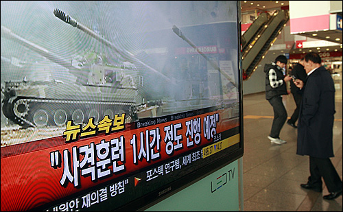 20일 오후 서울역 대합실에 설치된 TV 모니터를 통해 연평도에서 해상사격훈련을 시작했다는 긴급속보가 보도되자 지나가는 시민들이 걱정스런 마음으로 급하게 전화통화를 하고 있다.