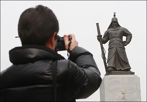보수·보강 작업을 마친 이순신 동상이 지난해 12월 23일 오전 서울 광화문 광장에 다시 설치되어 멋진 자태를 뽐내자 한 시민이 카메라로 사진을 찍고 있다.