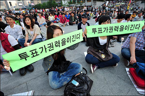 '6.2 지방선거' 를 하루 앞둔 지난 6월 1일, 서울 광화문 광장에서 시민들이 '투표가 권력을 이긴다' 라고 쓰인 선전물을 펼쳐 보이고 있다.