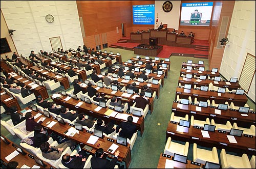 30일 새벽 서울시의회 본회의장에서 한나라당 시의원들(오른쪽)이 예산안 반대하며 전원 퇴장한 가운데, 여당 시의원들이 2011년도 예산안을 상정해 통과시키고 있다.