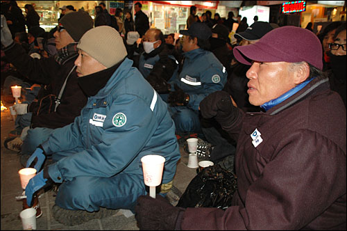  30일 저녁 부산 서면에서 열린 "예산안 날치기 전면 무효, 한진중공업 영도조선소 살리기 부산시민대회"에 참석한 노동자들이 촛불을 들고 구호를 외치고 있다.