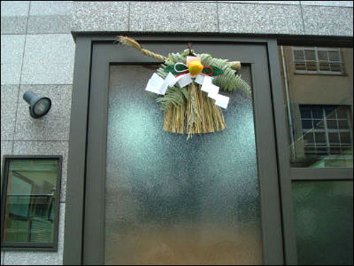 오사카 이쿠노구 골목 안 부동산 소개점 문 앞에 달아둔 마츠가자리(松飾り)입니다. 소박한 모습으로 겨울에 수확하는 잎이 달린 밀감이나 풀고사리가 장식으로 달려있습니다. 