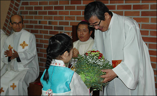 2일 오전 천주교 마산교구 진해 덕산동성당에서 김영식 신부 송별미사가 열렸다. 사진은 김영식 신부가 한 어린이로부터 꽃다발을 받고 있는 모습.