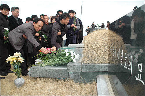  민주노총 경남본부 조합원들이 3일 오전 양산 솥발산 열사묘역에서 시무식을 연 뒤 고 배달호 열사의 묘소에 헌화참배하고 있다.