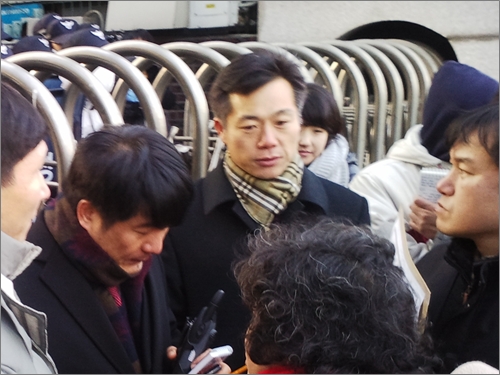 동작경찰서 관계자들(왼쪽, 가운데)이 입구를 막고 동작경찰서장을 만나겠다는 집회 참가자 대표인 김종철 진보신당 전 대변인(오른쪽)의 요구를 거절하고 있다.