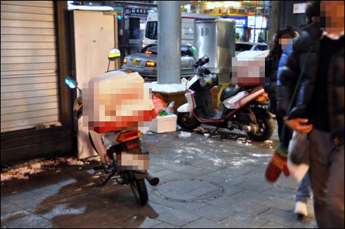 유명 피자 프랜차이즈 점포 앞에 세워진 배달 오토바이
