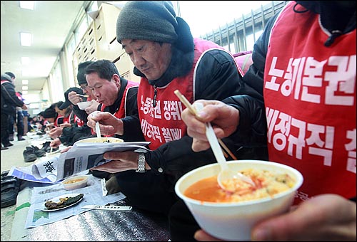 해고 통보를 받은 홍익대 청소·경비·시설 노동자들이 추운 농성장 바닥에서 국 한그릇과 김치, 김으로 점심을 해결하고 있다. 