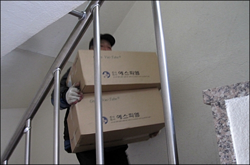 대한통운 택배노동장 최학렬씨가 무거운 박스를 들고 계단을 오르고 있다.(자료사진)