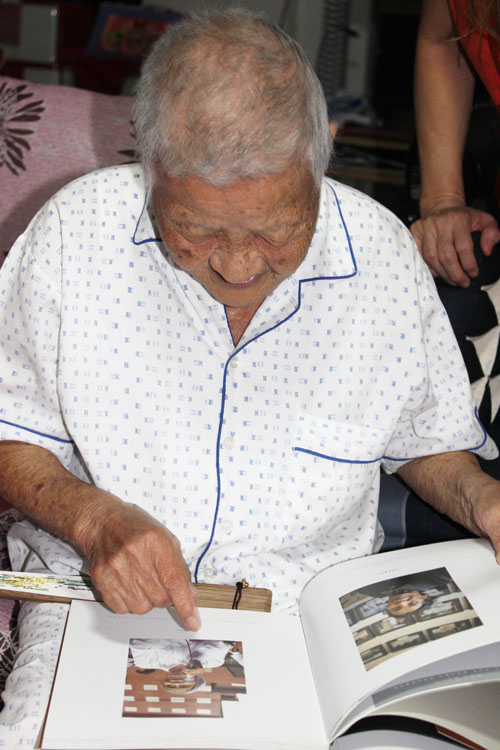 태국에 살고 있는 일본군'위안부' 피해자 노수복 할머니가 정대협 일행이 선물로 갖고간 사진첩 속에서 강덕경 할머니의 사진을 보고 있다.