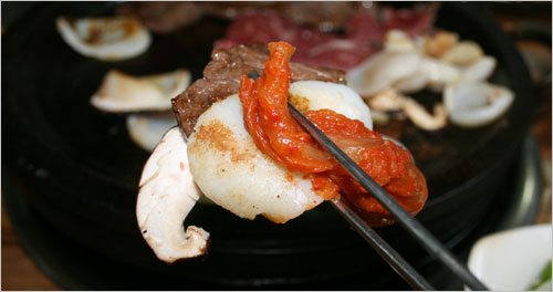 쇠고기와 키조개 표고버섯이 만나 삼합을 이룬다. 맛돌이는 묵은지 하나 더.