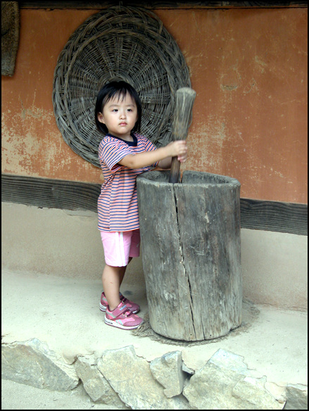 2004, 9, 5 한국민속촌에서 절구질을 하고 있는 어린이. 혼자 하는 것을 외절구라고 한다