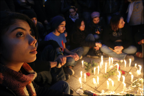 1월 22일(현지 시각) 튀니지 수도 튀니스에서 젊은이들이 촛불을 가운데 두고 둘러앉아 있다. 튀니지에서는 독재자를 권좌에서 끌어내리기 위해 위험을 마다하지 않고 시위를 하다 사망한 희생자들의 숭고한 정신을 기리고 그들의 죽음을 애도하기 위해 이날부터 사흘 동안 국기를 조기로 게양하고 방송국의 코란 암송 등의 의식이 계속됐다.