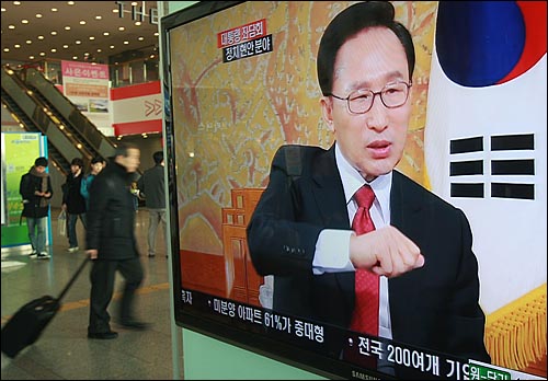 1일 오전 이명박 대통령의 '2011 신년방송좌담회-대통령과의 대화'가 생중계되는 서울역 대합실 TV 옆을 한 시민이 지나가고 있다.