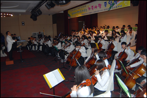 '우미마루' 오케스트라단이 졸업식장에서 음악을 연주하고 있다.  위미중학교는 전교생이 각각 바이올린, 첼로, 비올라, 플롯, 클라리넷 중 1악기를 익히는 활동에 참여하였고, 그 활동이 결실을 맺어 2009년 12월에는 '우미마루'라는 오케스트라단을 창단했다. 