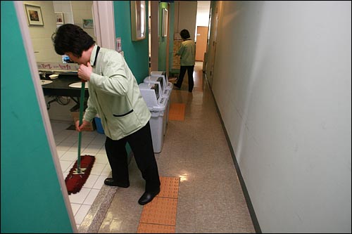 성동구청 청소용역 여성노동자들이 사무실에 붙어 있는 화장실을 청소하고 있다.