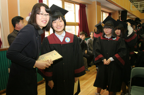 이날 졸업한 배우 남지현 양이 담임교사에게 졸업장을 받고 기념사진을 찍고 있다.