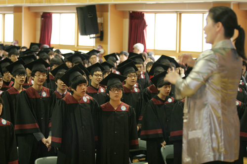 상정중 졸업식에서 교사의 지휘에 맞춰 합창을 하고 있는 졸업생들.