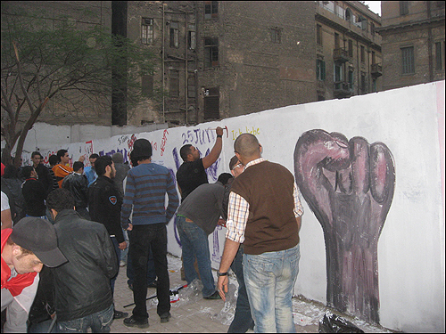 12일(현지 시각) 이집트 수도 카이로의 타흐리르 광장으로 향하는 길가에서 시민들이 독재자 무바라크 대통령을 물러나게 한 '1월 25일 혁명'을 기념하는 벽화를 그리고 있다. 시민들은 영어와 프랑스어 등으로 '나는 이집트를 사랑한다'는 문구 등도 적어 넣었다.