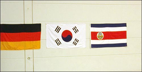 까를로스가 태권도 시범경기장 벽에 직접 걸어놓은 국기들.
독일, 꼬레아, 그의 조국 코스타리카 국기, 가운데 태극기를 두었다. 