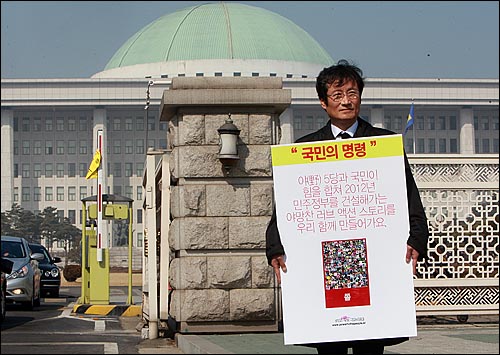 야권단일정당 창출을 위한 '백만송이 국민의 명령' 문성근 대표가 23일 오후 서울 여의도 국회 앞에서 2012년 민주정부 수립을 위해 민주·진보 진영의 야권단일 정당 구성을 촉구하며 1인 시위를 벌이고 있다.
