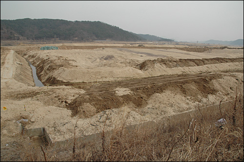 낙동강사업 19공구 공사장 옆에 있는 경남 의령군 지정면 성산마을 주민들은 침수로 피해를 입었다며 대책을 호소하고 있다. 사진은 낙동강 둔치를 높이는 공사를 벌이는 모습.