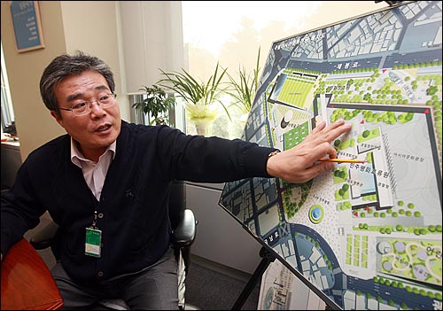이병훈 아시아문화중심도시추진단장이 국립아시아문화전당 조감도를 보며 구조를 설명하고 있다.
