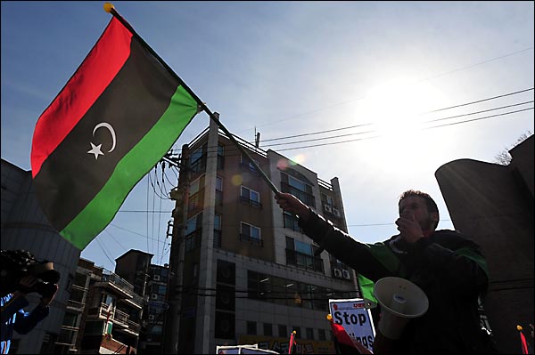 주한 리비아인과 아랍계 외국인들이 25일 오후 서울 용산구 이태원동 주한리비아대사관 앞에서 '카다피 퇴진' 시위를 벌이며 카다피의 집권 이전에 쓰이던 리비아 국기를 흔들고 있다. 
