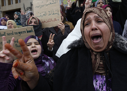 25일 리비아 벵가지에서 금요기도회를 앞두고 한 여성이 무아마르 카다피 리비아 국가원수의 퇴진을 요구하는 시위에 참가해 구호를 외치고 있다. 한편, 리비아 수도 트리폴리에서는 카다피 친위병력이 이슬람 사원에서 금요 예배를 마치고 거리로 나온 반정부 시위대를 향해 총격을 가해 수 명의 사망자가 발생했다.