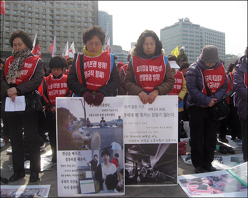 5일 서울광장에서 열린 '대학 비정규직 노동자 파업 승리 결의대회'에서 참가자들이 묵념을 하고 있다.