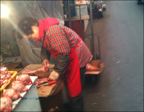 축산물시장의 상인이 고기를 손질하고 있다.