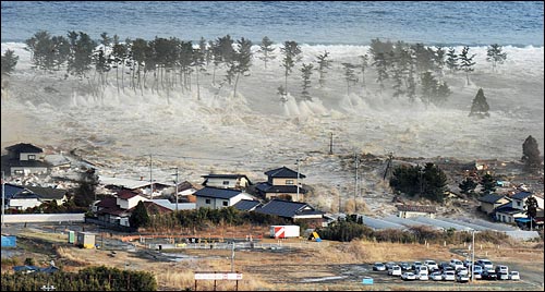 지난 11일 오후 일본 도호쿠(東北) 지방 부근 해저에서 일어난 대규모  강진으로 미야기현 나토리시 마을에 쓰나미가 덮치고 있다.