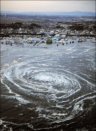 11일 오후 일본 도호쿠(東北) 지방 부근 해저에서 일어난 대규모  강진으로 이바라키현 오아라이 마을로 대형 쓰나미가 소용돌이 치며 덮치고 있다.