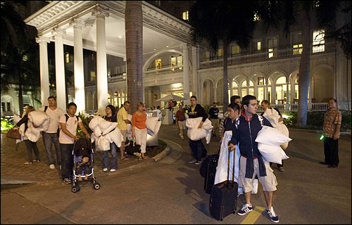 일본에서 발생한 강진이 하와이를 덮칠 것으로 예상되는 가운데 11일(현지시각) 하와이 호놀룰루의 관광객들이 호텔에서 나와 대피하고 있다. 