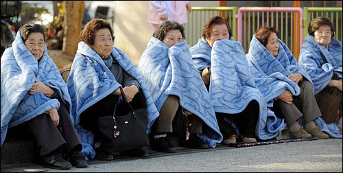 11일 오후 강진이 발생한 일본 도쿄에서 할머니들이 지진을 피해 담요를 덮어쓰고 길가에 앉아 있다.