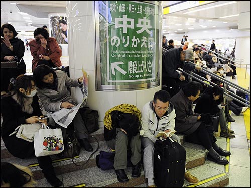 일본 도호쿠(東北) 지역에서 강진 사태가 발생한 가운데 11일 오후 도쿄 JR도쿄역 개찰구 근처에서 승객들이 운행 재개를 기다리고 있다.