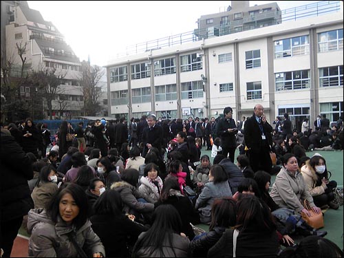  학교 운동장으로 대피한 사람들