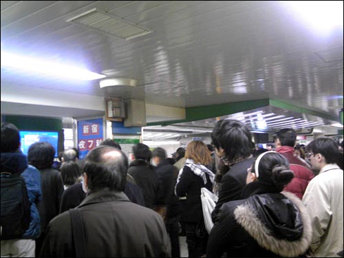 지하철역 TV에서 나오는 지진 관련 뉴스에 귀기울이는 도쿄 시민들.