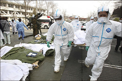 13일(현지시각) 일본 후쿠시마현 니혼마츠에 있는 후쿠시마 성평등센터 복합단지에 방사선 피폭 가능성이 있는 후타바 코세이 병원 환자들이 들것에 실려오고 있다.
