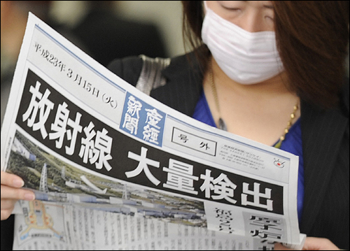 2011년 3월 15일 오사카 역 앞에서 한 시민이 후쿠시마 제1원자력 발전의 방사성 물질 유출을 전하는 호외를 보고 있다. 