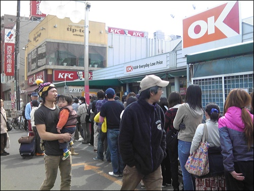 도쿄 시민들이 생필품을 구입하려고 길게 줄을 서 있다.