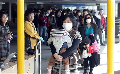 일본에서 출발한 항공기에 탑승했던 승객들이 17일 영종도 인천국제공항을 통해 입국하며 한국원자력안전기술원 관계자들의 안내에 따라 고정식 방사능 오염감시기를 통과하고 있다.