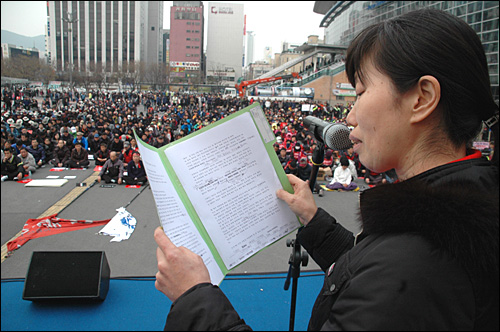  한진중공업.부산경제 살리기 시민대책위는 19일 오후 부산역광장에서 "한진중공업 정리해고 철회, 부실경영 책임자 처벌,  부산경제살리기 시민대회"를 열었다. 금속노조 한진중공업지회 박성호 대의원의 부인이 '가족 편지'를 낭송하고 있는 모습.