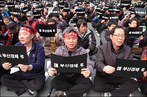  한진중공업.부산경제 살리기 시민대책위는 19일 오후 부산역광장에서 "한진중공업 정리해고 철회, 부실경영 책임자 처벌,  부산경제살리기 시민대회"를 열었다. 집회 참가자들이 '근조 부산경제'라고 쓴 손피켓을 들며 구호를 외치고 있는 모습.