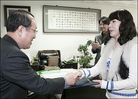  이학진 군산 부시장이 김혜영씨에게 명예시민증을 전달하고 있습니다.
