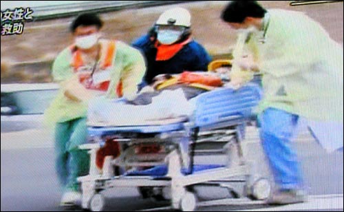 일본 경찰이 동북부 지진 열흘만인 20일 오후 4시 미야기현 이시노마키시 카도가와 마을 무너진 건물에서 80세 여성과 16세 소년 2명을 구조해 병원으로 옮기고 있다.(NHK TV 화면 촬영)