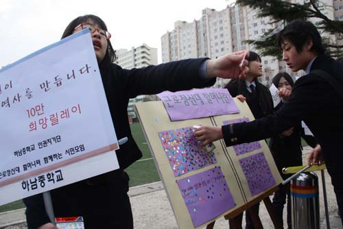 하남중학교 학생들이 지난 22일 등굣길 학생들에게 '10만 희망릴레이'를 홍보하고 있다.
