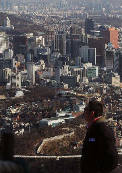 22일 결의대회를 마치고 인왕산 정상에 오른 한진중공업 조합원이 서울 시내를 내려다보고 있다.