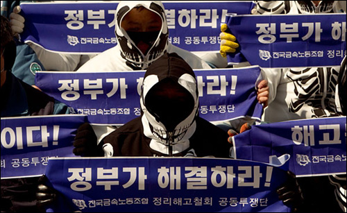 23일 오전 서울 광화문 세종문화회관 앞에서 열린 '해고노동자 문제 해결을 위한 공동선언 발표 기자회견'에 참가한 한진중공업 조합원들이'정부가 해결하라'가 적힌 손 펼침막을 들고 회견에 참가하고 있다.