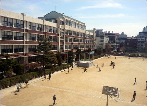 텅빈 중앙현관. 점심 시간 서울 ㅅ초 학생들 대부분은 쪽문으로 운동장에 나왔다. 